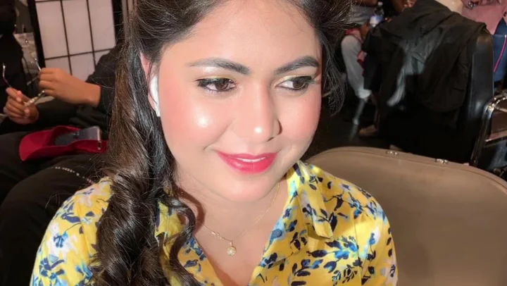 Client with finished soft-glam makeup and curled hair
