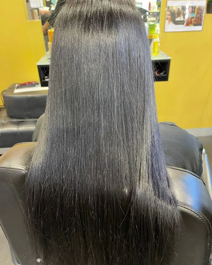 Near-black hair straightened to a high gloss after a smoothing treatment