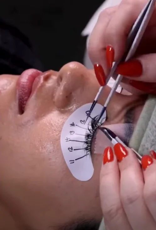 Two-tool lash isolation in progress, technician's hands either side of the eye