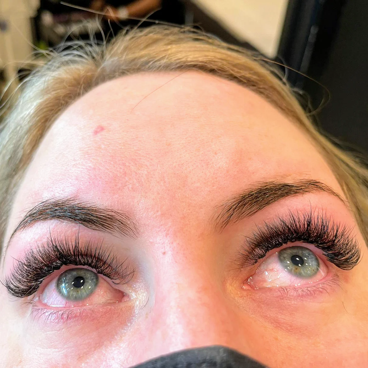 Fanned dark lash extensions on blue-grey eyes