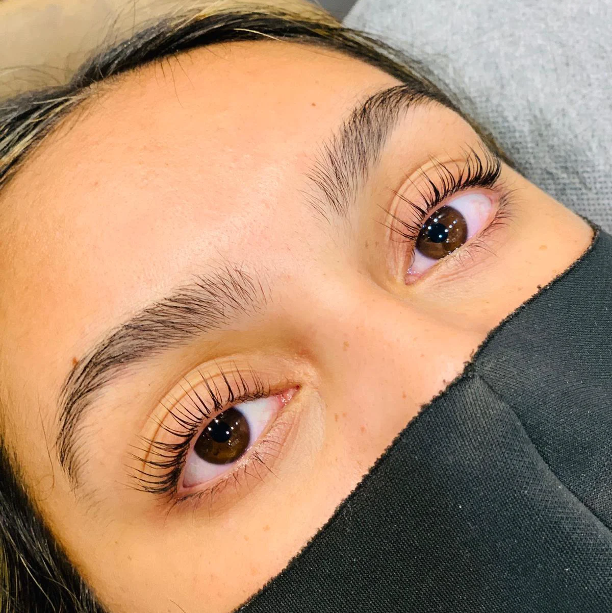 Soft natural-length lash extensions, reclining client